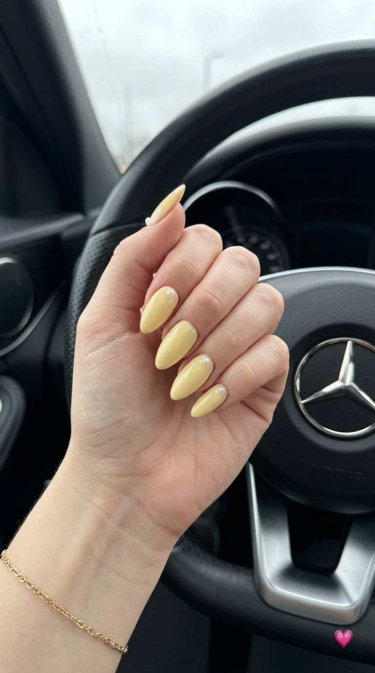 Almond Summer Nails 2026: Butter Yellow with Tiny Pearls Almond summer nails 2026 for fair skin: Sunny butter yellow with tiny pearls for casual outings.