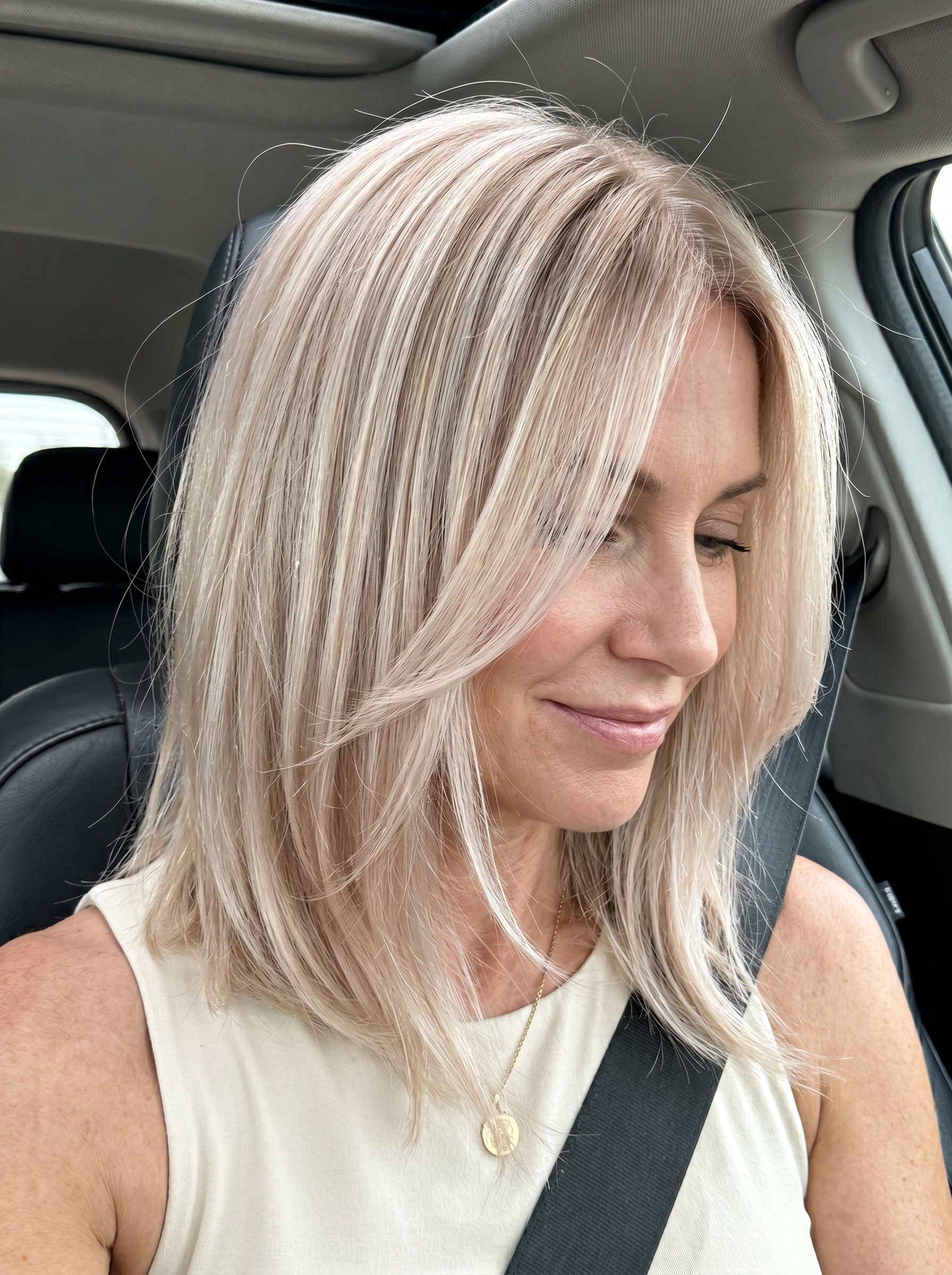 shoulder-grazing lob haircut champagne blonde with pearlescent finish, point-cut perimeter, face-framing pieces — glamorous summer 2026 haircut