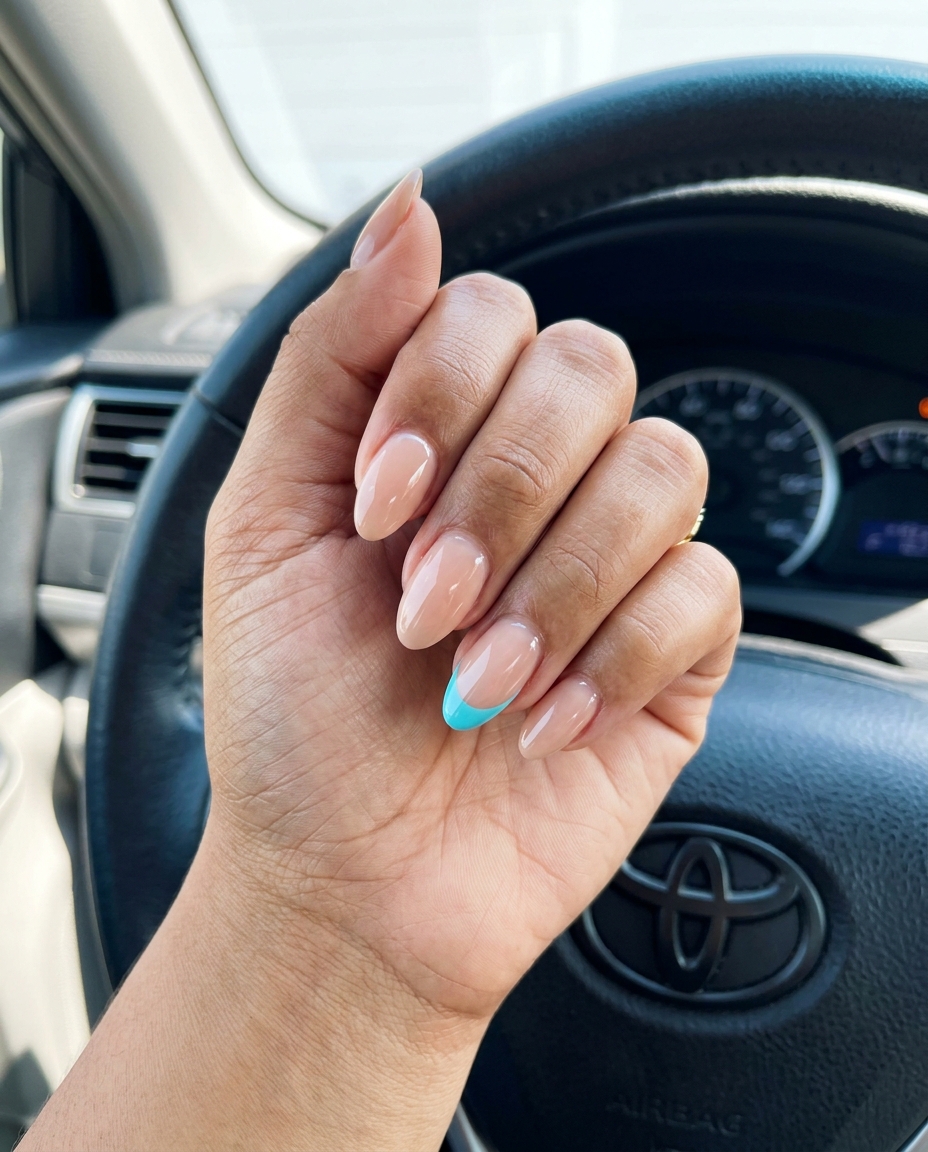 Cute summer nails 2026: Sheer nude with aqua blue French tip, medium almond shape, vacation style.