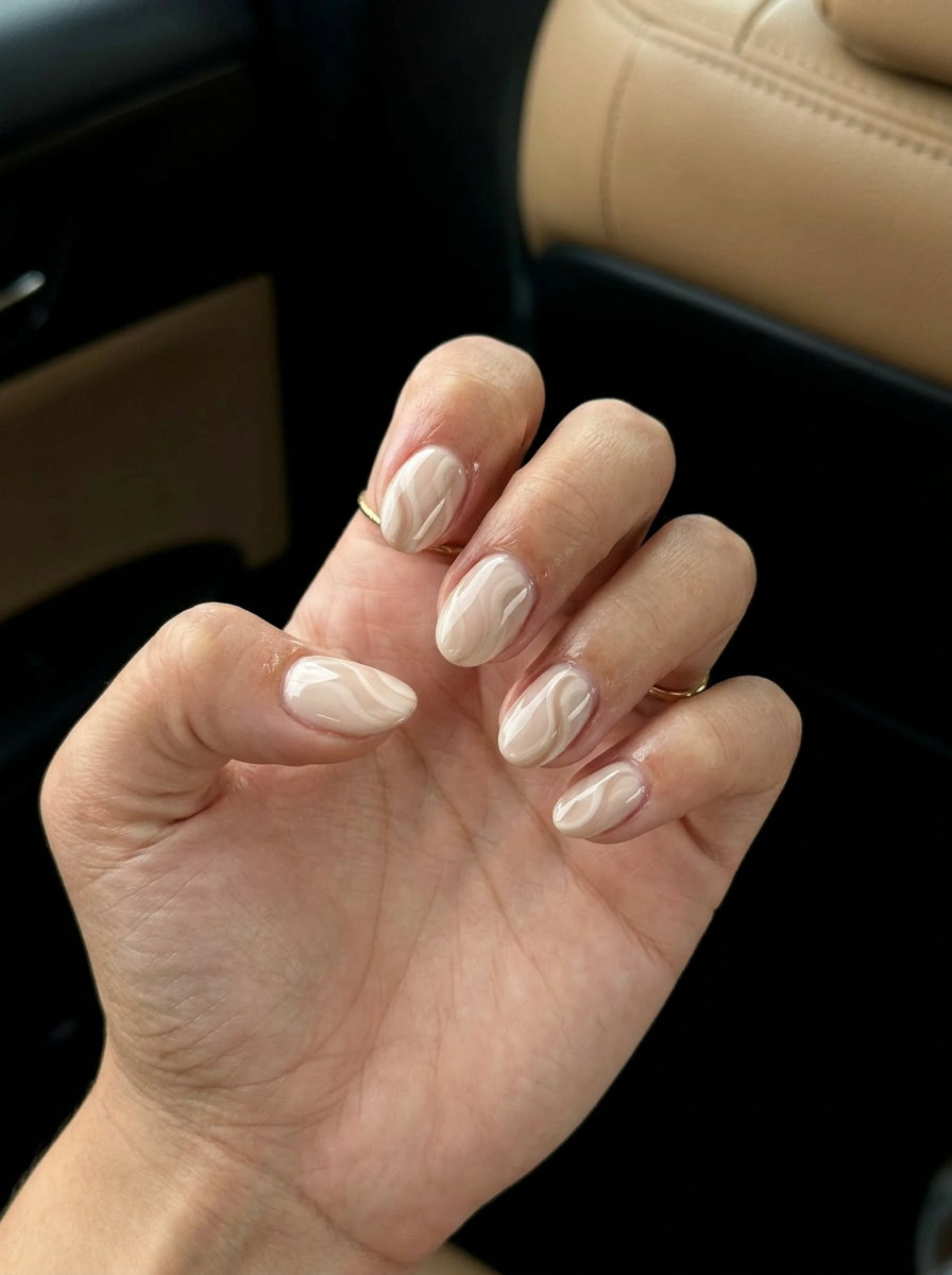 Chic nude swirls on short almond nails for sophisticated daily wear and formal events. Short summer nails 2026.
